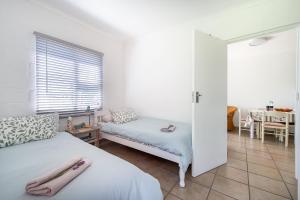 a bedroom with a bed and a couch and a table at Ria's Rest Self Catering Flatlet in Sedgefield +29 photos
