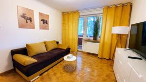 a living room with a couch and a television at Apartament Motylek in Hajnówka