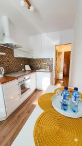 a kitchen with white cabinets and a table with bowls on it at Apartament Motylek in Hajnówka