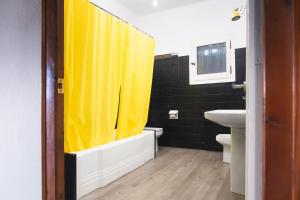 a bathroom with a yellow shower curtain and a sink at Casa Arbós Casa rural a Arbeca, les Garrigues in Arbeca +40 photos