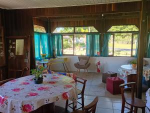 a room with a table and chairs and windows at Hotel pousada Araquari in Araquari