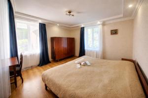 a bedroom with a bed and a desk and windows at Family hotel mountain panorama in Borjomi +31 photos