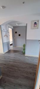 an empty room with white walls and wood floors at Ferienwohnung Rita in Aschendorf +2 photos