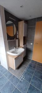 a bathroom with a sink and a mirror at Ferienwohnung Rita in Aschendorf