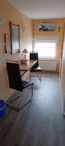 a room with a table and two chairs and a window at Ferienwohnung Rita in Aschendorf