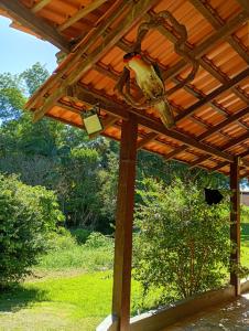 a wooden pergola with a roof on a yard at Hotel pousada Araquari in Araquari