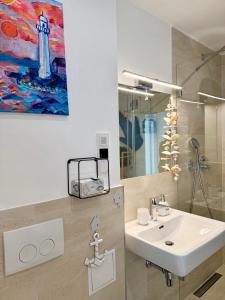 a bathroom with a sink and a painting on the wall at Apartment with a terrace in Vienna +163 photos