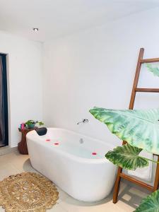 a white bath tub in a bathroom with a plant at The Courtyard Villa in Sigiriya
