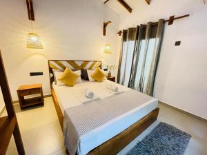 a bedroom with a large bed with yellow pillows at The Courtyard Villa in Sigiriya