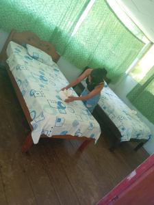a woman sitting on a bed in a room at Amazon Lodge Iquitos in Iquitos +4 photos