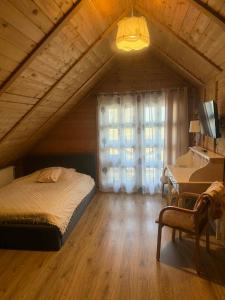 a bedroom with a bed and a desk in a attic at Karczma Biesiadna in Dalnia +48 photos