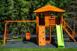 a wooden playset with a slide and a playground at Domki Tatra Loft in Ząb