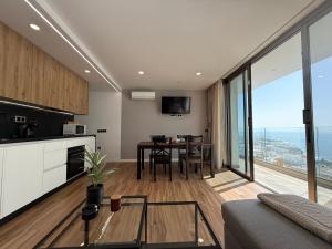 a kitchen and living room with a table and a view at Seba Deluxe Home in Puerto de Santiago