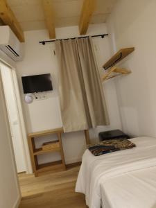 a room with two beds and a window with a curtain at Hotelet Bastio 12 in Ciutadella
