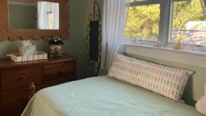a bedroom with a bed and a dresser and a window at Cutest Cottage On Central in Cape May Point
