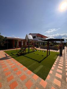 a playground in a courtyard with a building at Hotel Campestre Alma Nativa in Calarcá