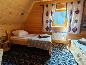 a bedroom with two beds in a wooden cabin at Kunatówka domek w Zębie in Ząb