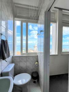 a bathroom with a toilet and a sink and windows at Melhor Localização do Centro Histórico de Salvador in Salvador