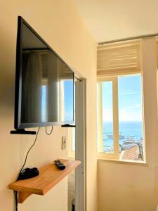 a flat screen tv hanging on a wall next to a window at Melhor Localização do Centro Histórico de Salvador in Salvador