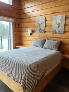 a bedroom with a bed in a wooden wall at Chalet L'Orée Étoilée in La Tuque