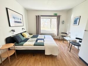 a bedroom with a bed and a table and chairs at B&B Villa Vila in Löttorp