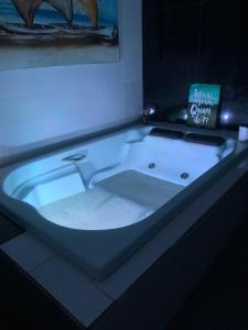 a white bath tub with a blue light in a room at vista mar suite luxo in Angra dos Reis