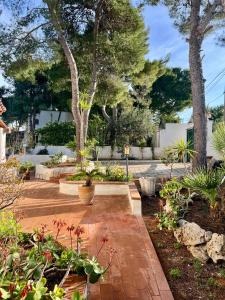 a garden with plants and trees and a brick walkway at Villa Calipso in Taranto