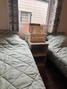 a bedroom with two beds and a book on a table at Vakantiehuisje op 5 star kindercamping in Mariënberg +33 photos