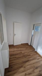 an empty room with a door and a wooden floor at Viktoria's Appartment 2 in OB-Mitte in Oberhausen