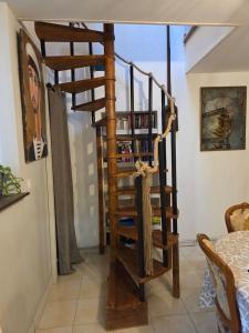 a wooden spiral staircase in a room with a table at La Pomme in Douvres-la-Délivrande
