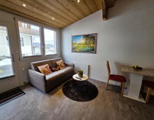 a living room with a couch and a table at Lilo's one-room apartment in Beatenberg