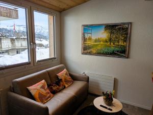 a living room with a couch and a painting on the wall at Lilo's one-room apartment in Beatenberg