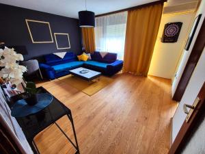 a living room with a blue couch and a table at Stan na dan Koprivnica-Comfort in Koprivnica