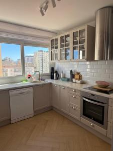 a large kitchen with white cabinets and a window at Costa blancavibes, Solo Familias in Playa de Gandia