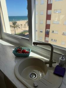 a sink with a window with a view of the beach at Costa blancavibes, Solo Familias in Playa de Gandia +15 photos