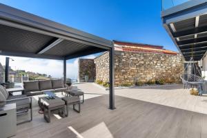 an outdoor patio with furniture and a stone wall at The Green Valley Porto Moniz in Achadas da Cruz