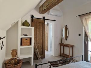a bedroom with a bed and a wooden door at Bagolyvölgy Tulkó Ház in Balatonhenye