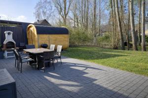 a patio with a table and chairs and a backyard at Ferienhaus Seerose - Sauna, eingezäunter Garten, Hunde, 3 min zum See in Göhren-Lebbin +54 photos