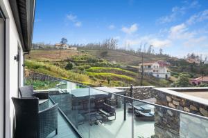 a balcony of a house with a view of a hill at The Green Valley Porto Moniz in Achadas da Cruz
