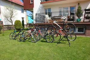 a group of bikes parked in the grass in front of a house at Anmar Pokoje Narty Rowery in Stronie Śląskie