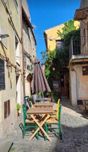 a table and chairs with an umbrella on a street at Casa Odara suite centro storico in Calcata