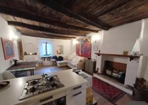 a kitchen with a stove and a living room at Casa Odara suite centro storico in Calcata +9 photos