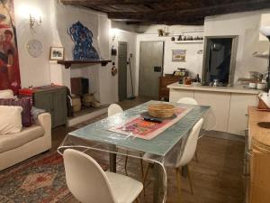 a kitchen and living room with a table and chairs at Casa Odara suite centro storico in Calcata