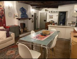 a kitchen and living room with a table and chairs at Casa Odara suite centro storico in Calcata