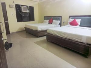 a bedroom with two beds and a air conditioner at Hotel R Himalayan in Mohali