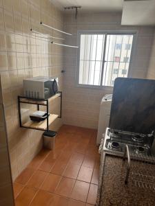 a kitchen with a stove and a sink in a room at Apartamento Prático Completo in Goiânia