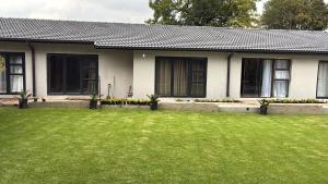 a house with a green lawn in front of it at Grey heron in Boksburg