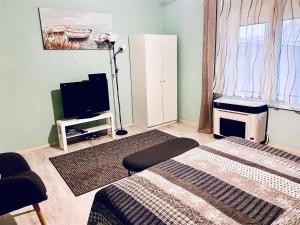 a living room with a bed and a tv at Lelle-kert Apartman 02 in Balatonlelle