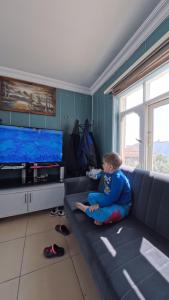 a young boy sitting on a couch in a living room at Aspawa Hotel in Pamukkale
