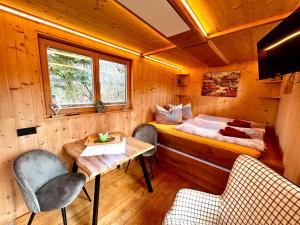 a room with a bed and a table and chairs at Vollholz-Ferienhaus Herbert's Alte Gärtnerei im Naturpark Zittauer Gebirge in Hainewalde +21 photos